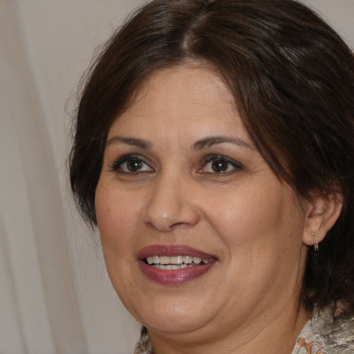 Joyful white adult female with medium  brown hair and brown eyes