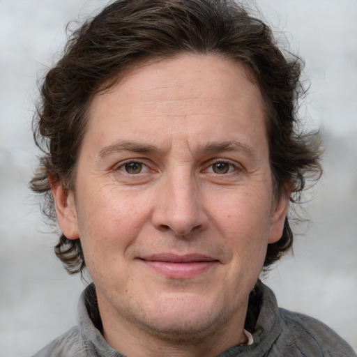 Joyful white adult male with medium  brown hair and grey eyes