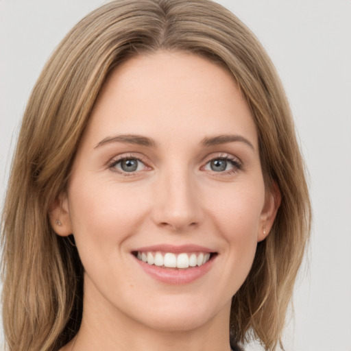 Joyful white young-adult female with long  brown hair and green eyes