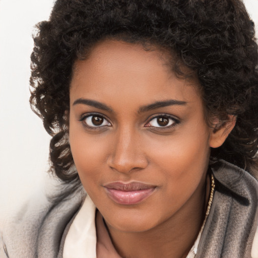 Joyful black young-adult female with long  brown hair and brown eyes