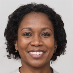 Joyful black adult female with medium  brown hair and brown eyes