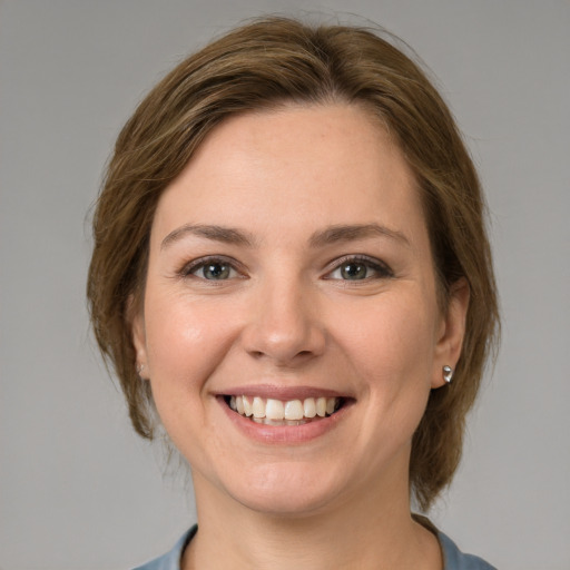 Joyful white young-adult female with medium  brown hair and grey eyes