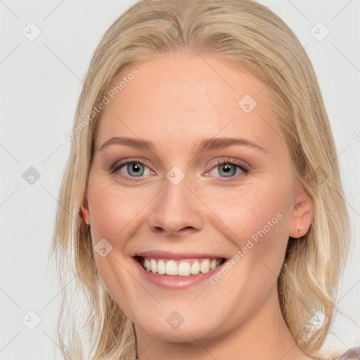 Joyful white young-adult female with long  brown hair and blue eyes