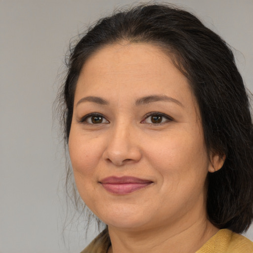 Joyful latino adult female with medium  brown hair and brown eyes