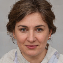 Joyful white adult female with medium  brown hair and blue eyes