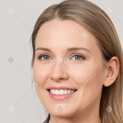 Joyful white young-adult female with long  brown hair and blue eyes