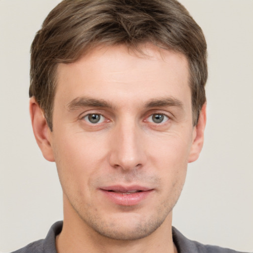 Joyful white young-adult male with short  brown hair and grey eyes