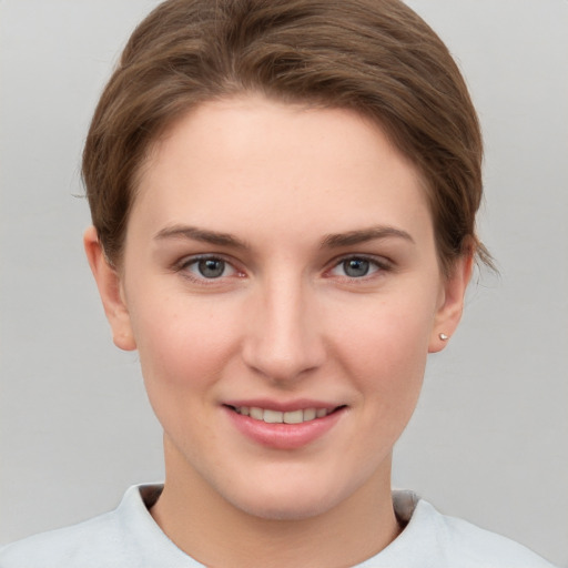 Joyful white young-adult female with short  brown hair and grey eyes