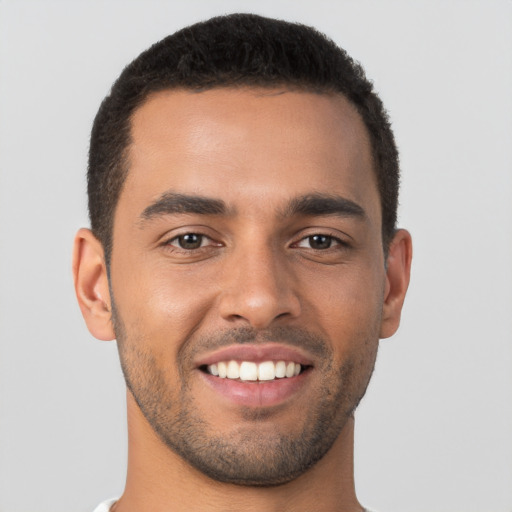 Joyful latino young-adult male with short  brown hair and brown eyes