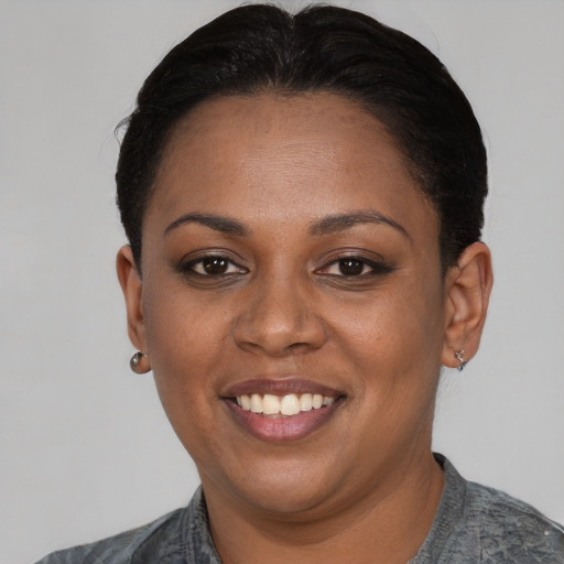 Joyful black young-adult female with short  black hair and brown eyes