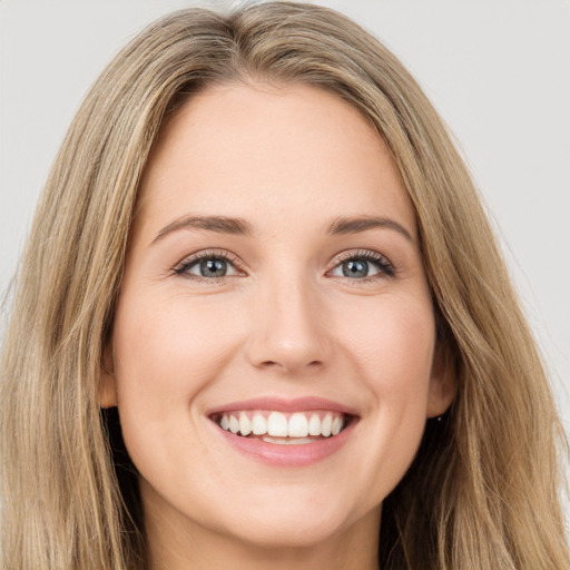 Joyful white young-adult female with long  brown hair and green eyes