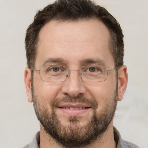 Joyful white adult male with short  brown hair and brown eyes