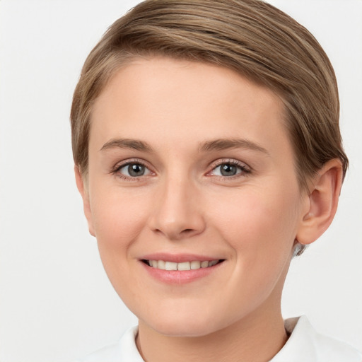 Joyful white young-adult female with short  brown hair and green eyes