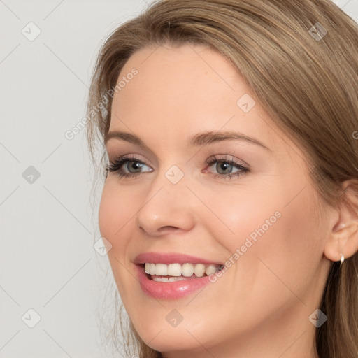 Joyful white young-adult female with long  brown hair and grey eyes