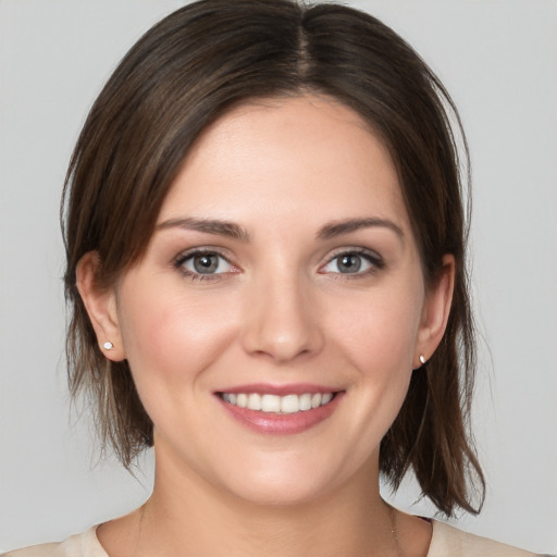 Joyful white young-adult female with medium  brown hair and grey eyes