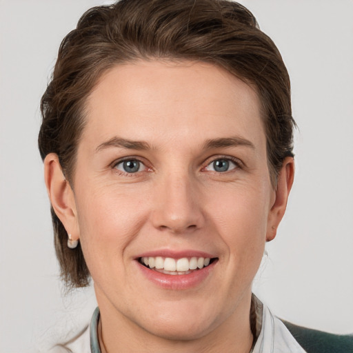 Joyful white adult female with medium  brown hair and grey eyes