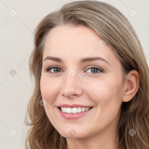 Joyful white young-adult female with long  brown hair and blue eyes