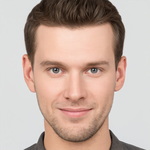 Joyful white young-adult male with short  brown hair and grey eyes