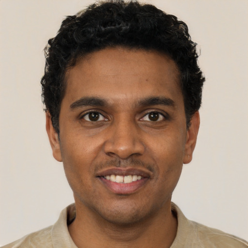 Joyful black young-adult male with short  black hair and brown eyes
