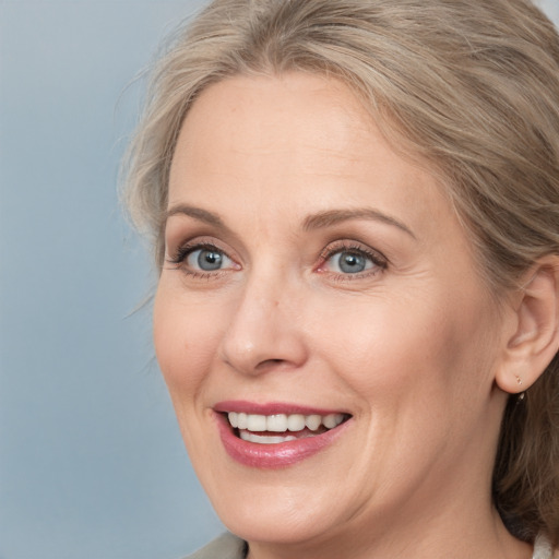 Joyful white adult female with medium  brown hair and blue eyes