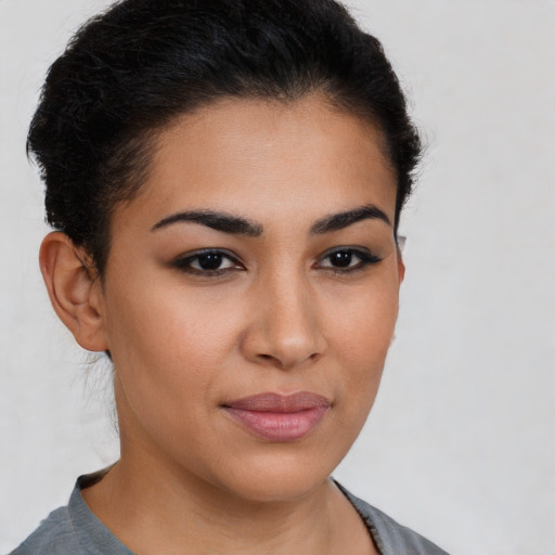 Joyful latino young-adult female with short  brown hair and brown eyes