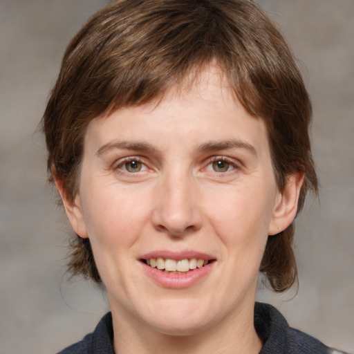 Joyful white adult female with medium  brown hair and grey eyes