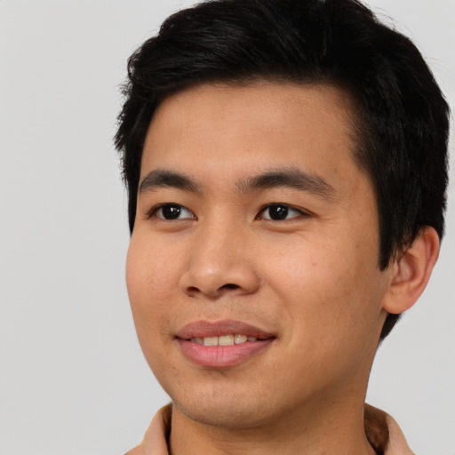 Joyful asian young-adult male with short  brown hair and brown eyes