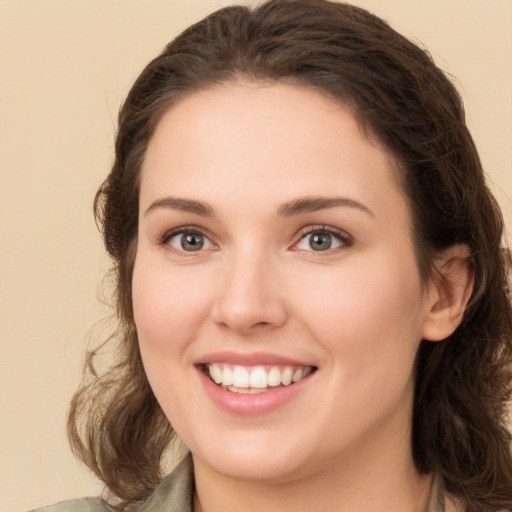 Joyful white young-adult female with long  brown hair and green eyes