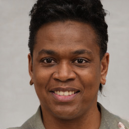 Joyful black young-adult male with short  black hair and brown eyes