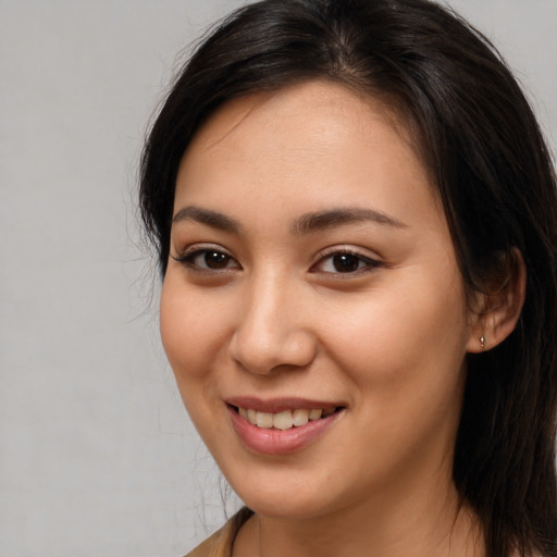 Joyful asian young-adult female with long  brown hair and brown eyes