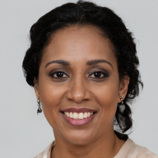 Joyful latino adult female with medium  brown hair and brown eyes