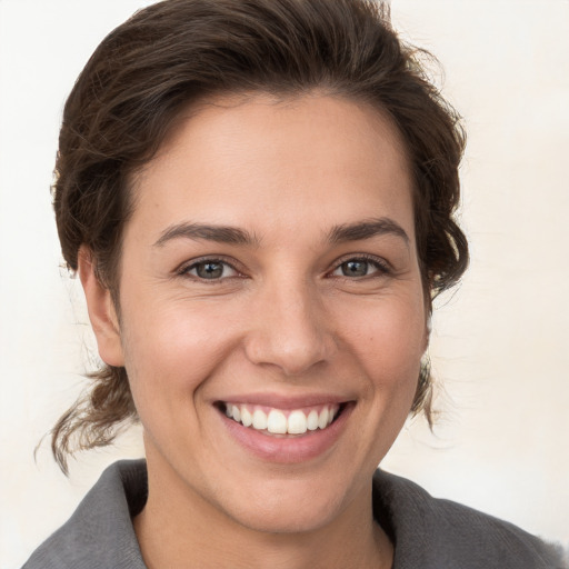 Joyful white young-adult female with short  brown hair and brown eyes