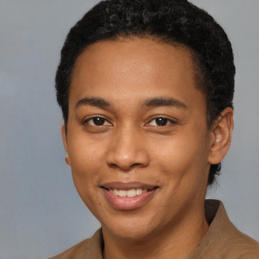 Joyful black young-adult male with short  brown hair and brown eyes