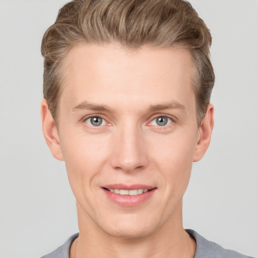 Joyful white young-adult male with short  brown hair and grey eyes