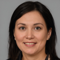 Joyful white adult female with long  brown hair and brown eyes