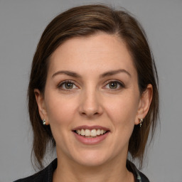 Joyful white young-adult female with medium  brown hair and grey eyes