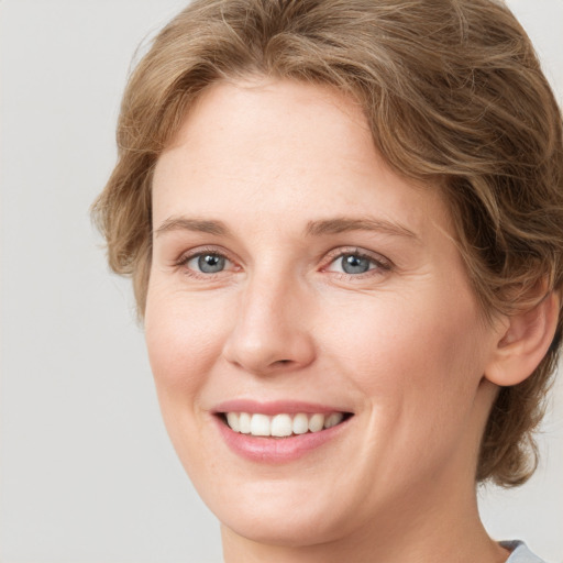 Joyful white young-adult female with medium  brown hair and blue eyes