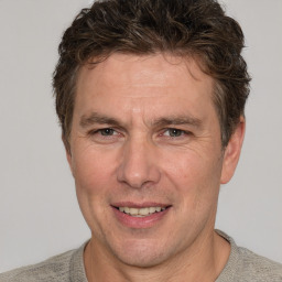 Joyful white adult male with short  brown hair and grey eyes