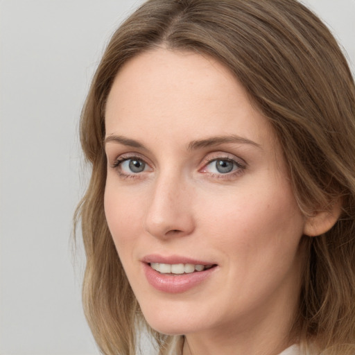 Joyful white young-adult female with long  brown hair and grey eyes