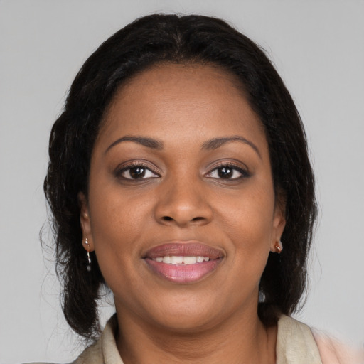 Joyful black adult female with long  black hair and brown eyes
