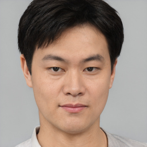 Joyful asian young-adult male with short  black hair and brown eyes
