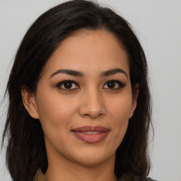 Joyful latino young-adult female with long  brown hair and brown eyes