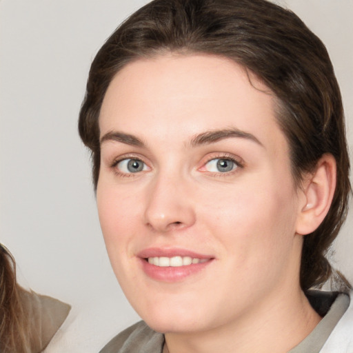 Joyful white young-adult female with medium  brown hair and green eyes