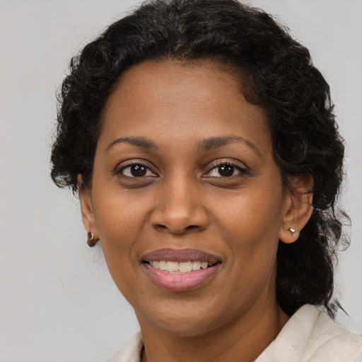 Joyful black adult female with medium  brown hair and brown eyes