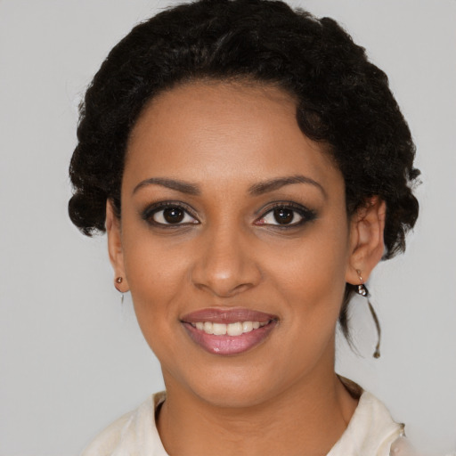 Joyful black young-adult female with short  black hair and brown eyes