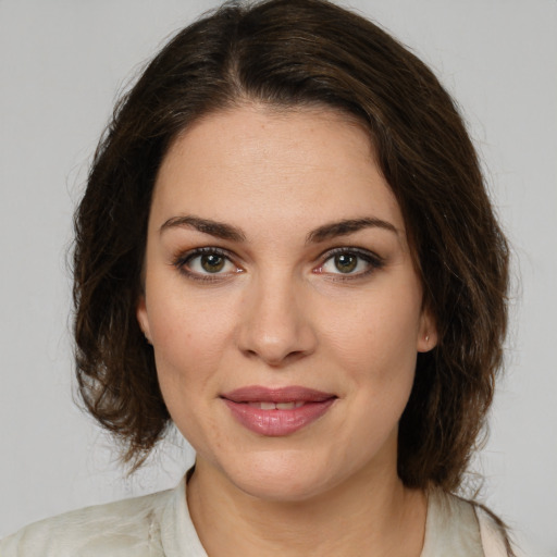 Joyful white young-adult female with medium  brown hair and green eyes