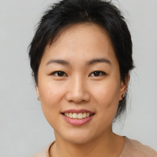 Joyful asian young-adult female with medium  brown hair and brown eyes