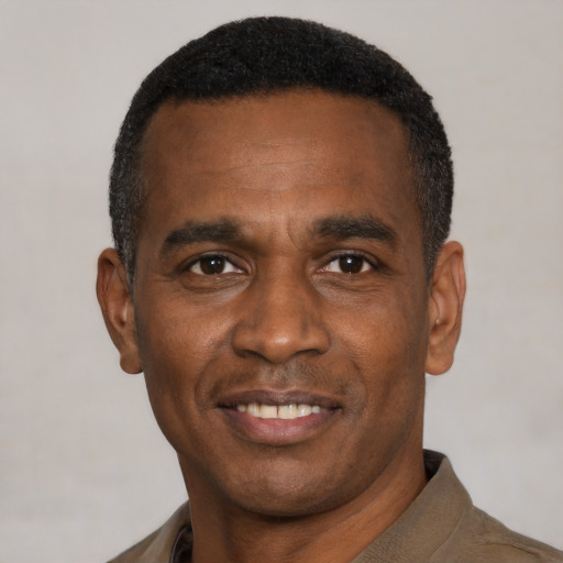 Joyful black young-adult male with short  black hair and brown eyes
