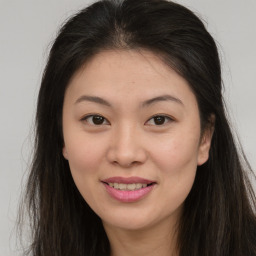 Joyful asian young-adult female with long  brown hair and brown eyes