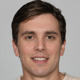 Joyful white young-adult male with short  brown hair and grey eyes